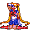 Pixel art of a kneeling anime character with long blonde pigtails, blue sailor uniform, red bow, and red boots, holding a white and blue object above her head against a gray background.