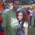 A pixelated image shows a person in a green shirt with white text over a blurred background of people and colors.