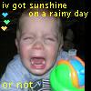 A child with closed eyes and mouth open in a cry, holding a colorful toy, with overlaid text and heart icons.