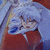 Animated character with silver hair and red clothing, eyes closed in a serene expression against a blue background.