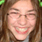 A pixelated image with a blue background, green text, and a photo of a smiling person on the left.