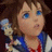 Pixelated close-up of a character with light brown hair, blue eyes, and a neutral expression wearing a blue and white outfit.