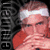 Static pixelated image of a person with red hair and white headband, partially obscured by vertical text on the left side against dark background.