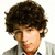 Pixelated portrait of a person with dark brown curly hair, light skin tone, and visible facial features including eyes, nose, mouth, and beard stubble.