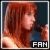 Pixelated profile icon showing a person with long reddish-brown hair in profile view, wearing dark clothing against a gradient background with warm and cool tones.