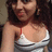 A pixelated image of a person with long dark hair wearing a white and red strapless top, cropped to show the upper body against a blurred background.