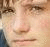 A pixelated image split into two sections: a close-up of a person's face on the left and red text with a heart symbol on the right.