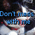 A pixelated image of a cat with black and white fur, red accents on its face, and blue text reading "Don't mess with me" overlaid.