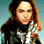 A pixelated contact sheet showing two frames of an animated icon featuring a woman with long brown hair and green text reading "Original Icons .com" on a dark green background.