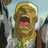 Pixelated image of a character with light brown hair and a green top, mouth open in a shout, next to black background with white text reading 'AnimeIM' and 'com'.