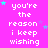 Pixelated text repeats 'you're the reason i keep wishing' on a bright pink background with scattered cyan and purple stars.