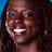 Pixelated close-up of a smiling person with long dark hair against a blue background, rendered in low-resolution 48x48 pixels with visible dithering and color blending.