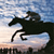 Pixelated static image of a horse and rider silhouette against a gradient sky background with visible dithering and anti-aliasing artifacts.