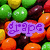 Pixelated candy background with fruit-themed text overlays in purple, pink, and blue, transitioning to yellow text on a gray