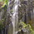 A pixelated static image shows a vertical light streak against a blurred background of green and brown tones.
