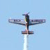 A pixelated aircraft icon with outstretched wings against a light blue background, featuring a white vertical trail beneath its fuselage.