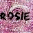 Pixelated pink and white background with bold black text reading "ROSIE ROSIE" in a repeating pattern across the frame.