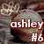 A circular icon with a textured surface, featuring red text reading 'ashley #6' over it and a light-colored floral design in the top-left corner.