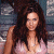 A pixelated image of a woman with long brown hair wearing a light-colored top, positioned next to green text reading 'Original Icons .com' on a dark background.