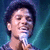 Pixelated image of a person with dark hair holding a microphone against a blue gradient background.