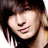 Pixelated close-up of a person with dark hair and a black top, showing a partial face with a slight smile.