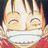Pixelated anime-style character with closed eyes and wide smile, wearing red garment, next to black background with white text.