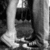Black-and-white pixelated image of a figure in dark clothing standing near vertical structures with light and shadow gradients.