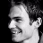 Black-and-white pixelated profile of a smiling person with dark hair on left, green background with bright green text 'OriginalIcons.com' on right.
