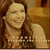 A pixelated static image shows a person with long brown hair wearing a sleeveless top, smiling against a warm-toned background.