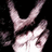 Pixelated image of a light-skinned hand making a peace sign against black background with white and pink tones.