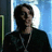 Pixelated image of a person with dark hair and a dark shirt, overlaid with green pixelated text on a black background.
