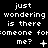 Pixelated text repeats across three on a black background with varying symbols beneath the phrase 'just wondering is there someone for me?'