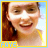Pixelated portrait of a smiling person with brown hair, wearing yellow clothing and a dark earring, against light blue background with yellow border.