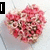 A heart-shaped arrangement of pink and white flowers on a light background, with text overlays changing across frames.