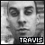 Static grayscale pixel art icon featuring a stylized human face with bold text "TRAVIS" at the bottom, rendered in low-resolution 256x256 pixels.