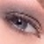 A close-up of a human eye with a dark pupil, visible eyelashes, and light skin tones surrounding the eye.