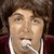 A six- shows a person in a maroon jacket with white trim singing into a microphone, transitioning from looking up to bowing down