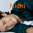 A person in a dark green shirt lies on a white surface with orange text above and below them, displaying 'Nidhi' and 'Loves' in the top section and 'ORLANDO' in the bottom section.