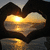 Heart-shaped hands frame a sunset over water with a bright sun reflection, displayed in a of four
