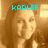 Pixelated image of a person with long brown hair and light skin, overlaid with cyan text reading KARLEE against a warm-toned background.
