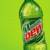 Two green soda bottles with red labels on a bright green background, text reads DO THE DEW.