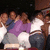 Group of people in casual clothing posing together with arms around each other, some wearing purple and white tops.