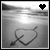 A 4-frame contact sheet of a grayscale animated icon showing a heart with an arrow drawn in sand on a beach, with the top-right corner displaying a pixelated heart that changes color across frames.