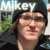 A pixelated image of a person wearing dark clothing and a cap, with 'MIKEY' text above the head against an outdoor background.
