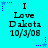 Cyan background with repeated text "I Love Dakota 10/3/08" and blue star-shaped pixel decorations in corners.