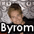 Pixelated image of a person with light brown hair wearing dark clothing, set against a gray textured background with white text elements and the word 'Byrom' in large white letters at bottom.