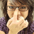 A pixelated close-up of a person with long dark hair wearing glasses and a purple top, making a hand gesture near their face.