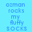 Pixelated text 'ozman rocks my fluffy socks' repeated across a with alternating light blue and purple background sections