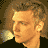 A 48x48 pixel animated buddy icon featuring a side-profile of a person with curly hair and a yellow light effect on the left, paired with a blue text label "nick" on a cloudy sky background.