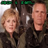 Two people in military-style jackets stand side-by-side against a blurred outdoor background with trees, with text overlays changing across frames.